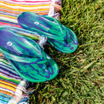 Slappas Arch Support Thongs - Blue Green displayed on the grass and with a towel