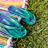 Slappas Arch Support Thongs - Blue Green displayed on the grass and with a towel