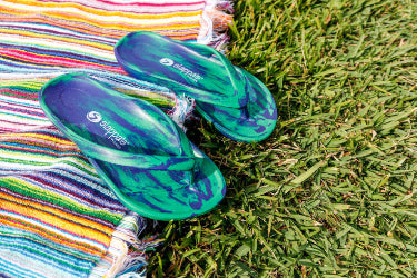 Slappas Arch Support Thongs - Blue Green displayed on the grass and with a towel